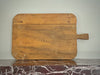 Wooden cutting board with a handle on a marble surface