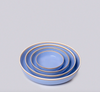 Set of three blue ceramic bowls with raw natural clay rims