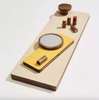Wooden and yellow magnetic tray with mirror and cylindrical items on a light background