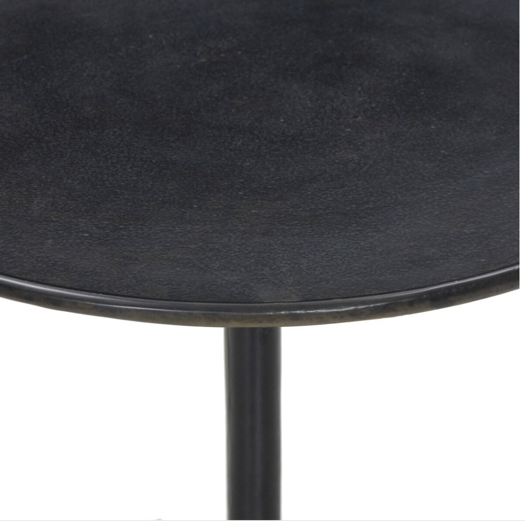 Round black side table with a white background