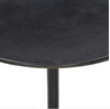 Round black side table with a white background