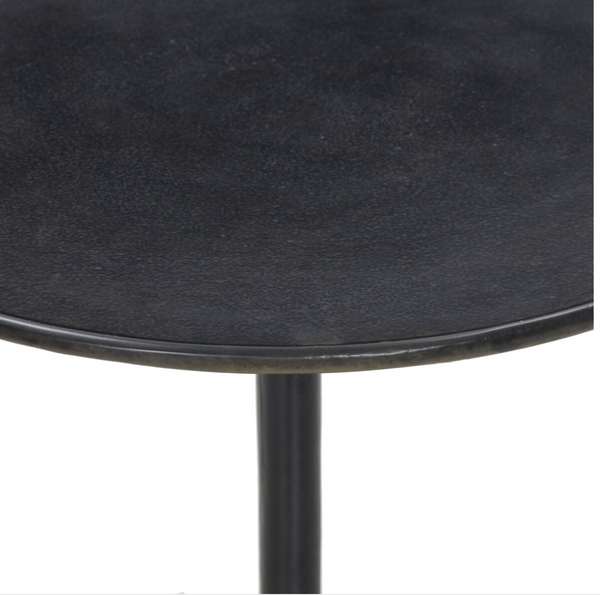 Round black side table with a white background