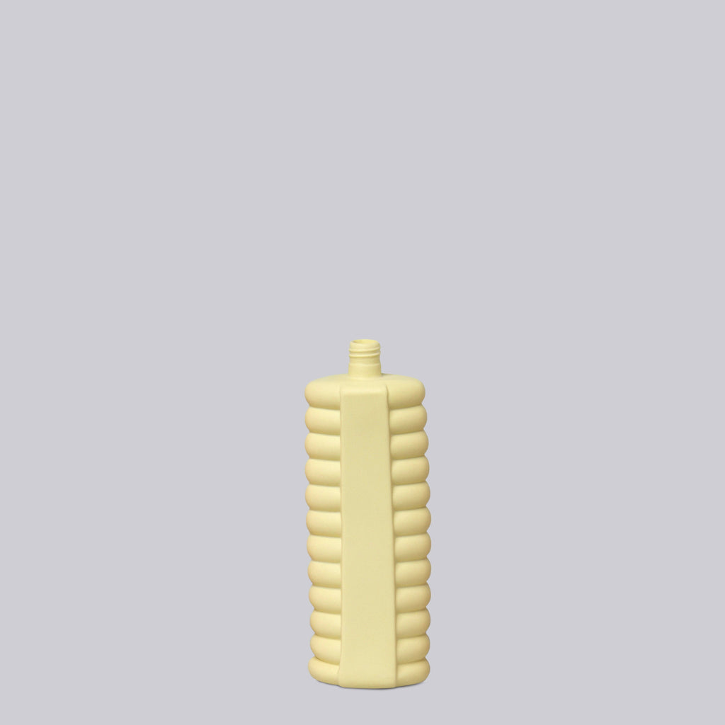 Yellow ribbed bottle on a light gray background