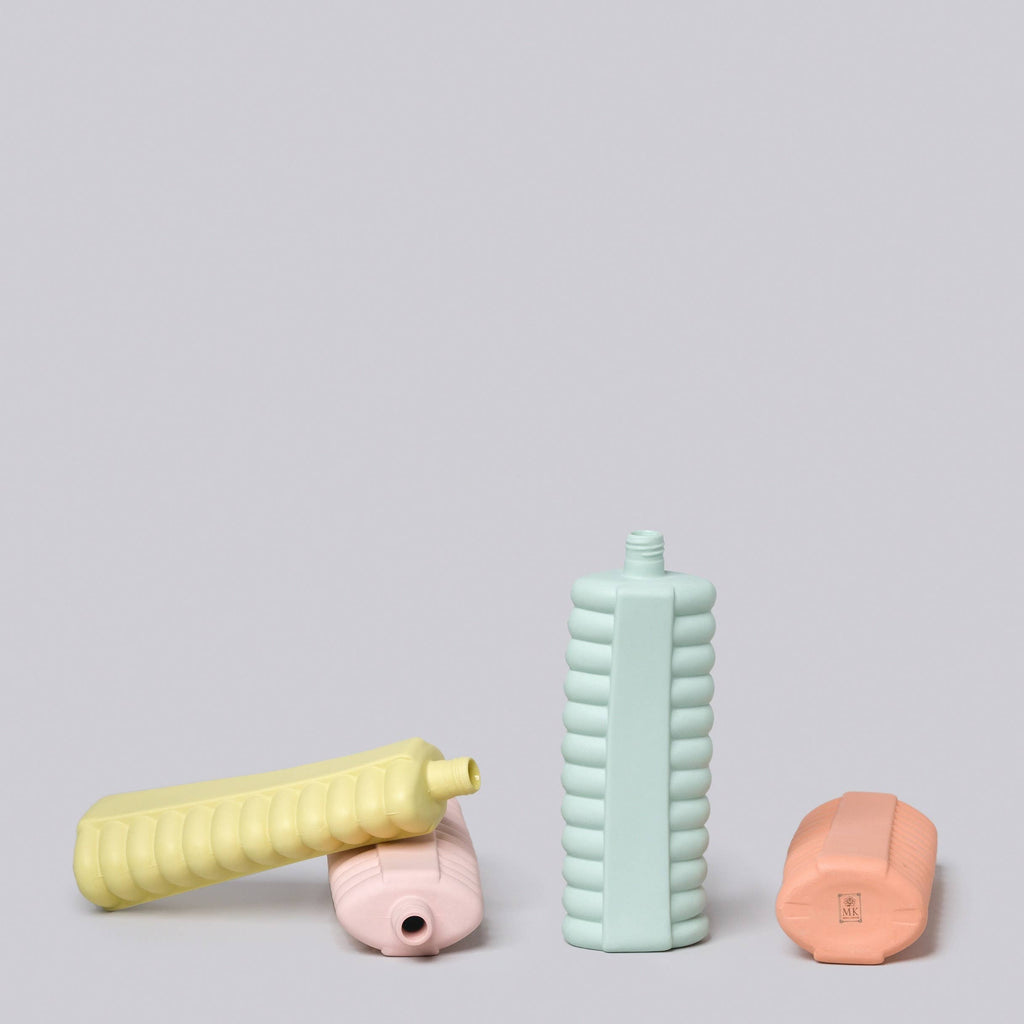 Three colorful bottles on a light gray background