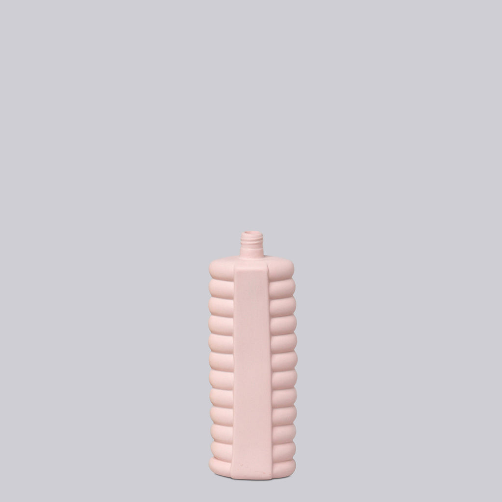 Pink textured bottle on a light gray background