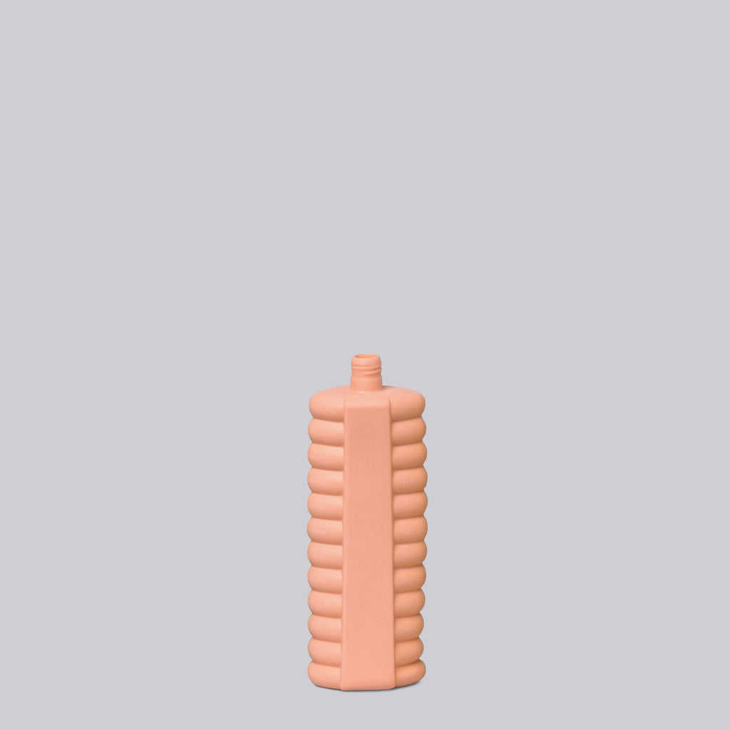 Pink textured bottle on a light gray background