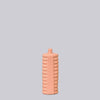 Pink textured bottle on a light gray background