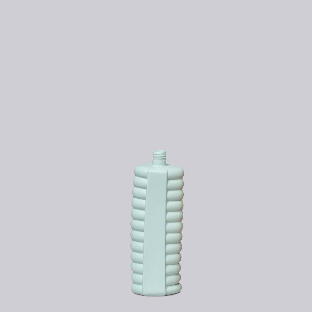 Light blue textured bottle on a light gray background