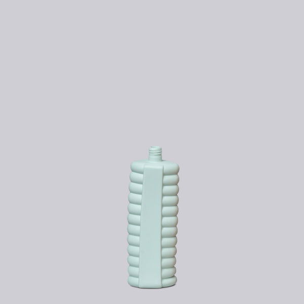 Light blue textured bottle on a light gray background