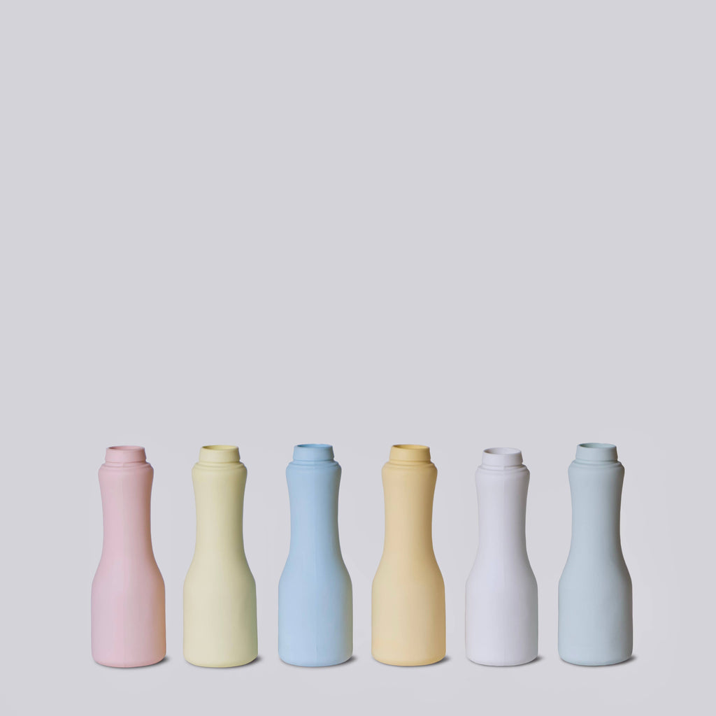 Set of six colorful ceramic bottles on a light gray background