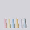 Set of six colorful ceramic bottles on a light gray background