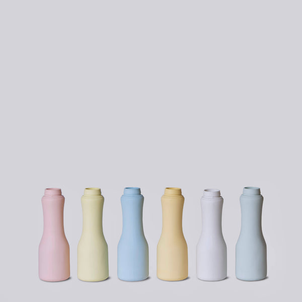 Set of six colorful ceramic bottles on a light gray background