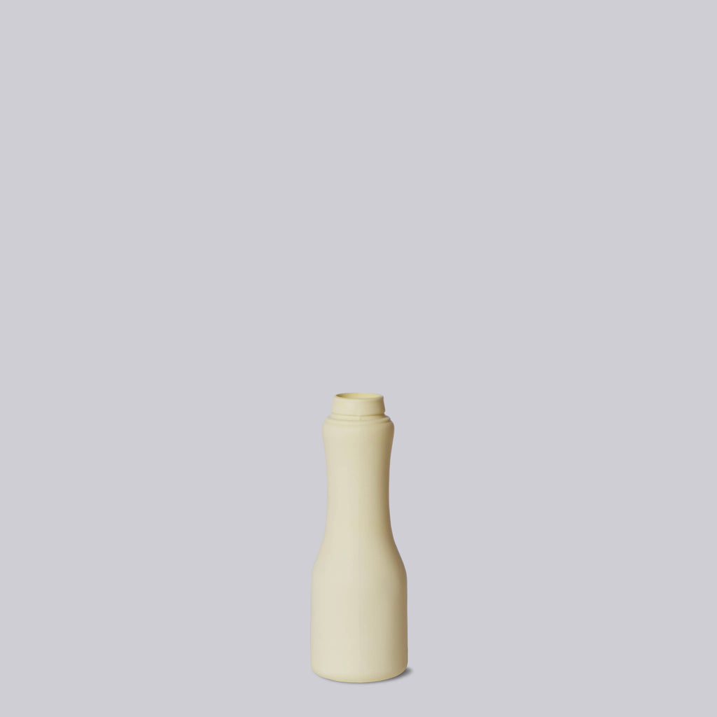Beige and light yellow ceramic bottle on a light gray background
