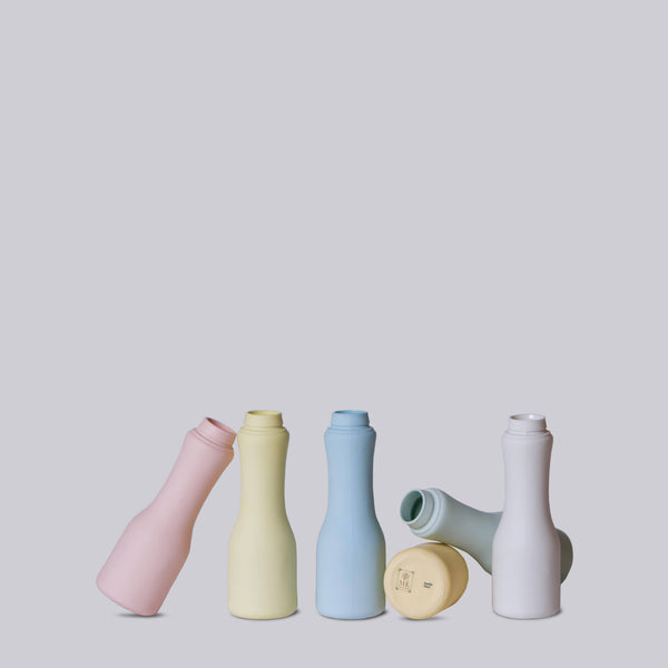 Set of colorful ceramic bottles on a light gray background