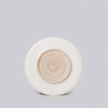Round ceramic object with concentric circular design on a light gray background