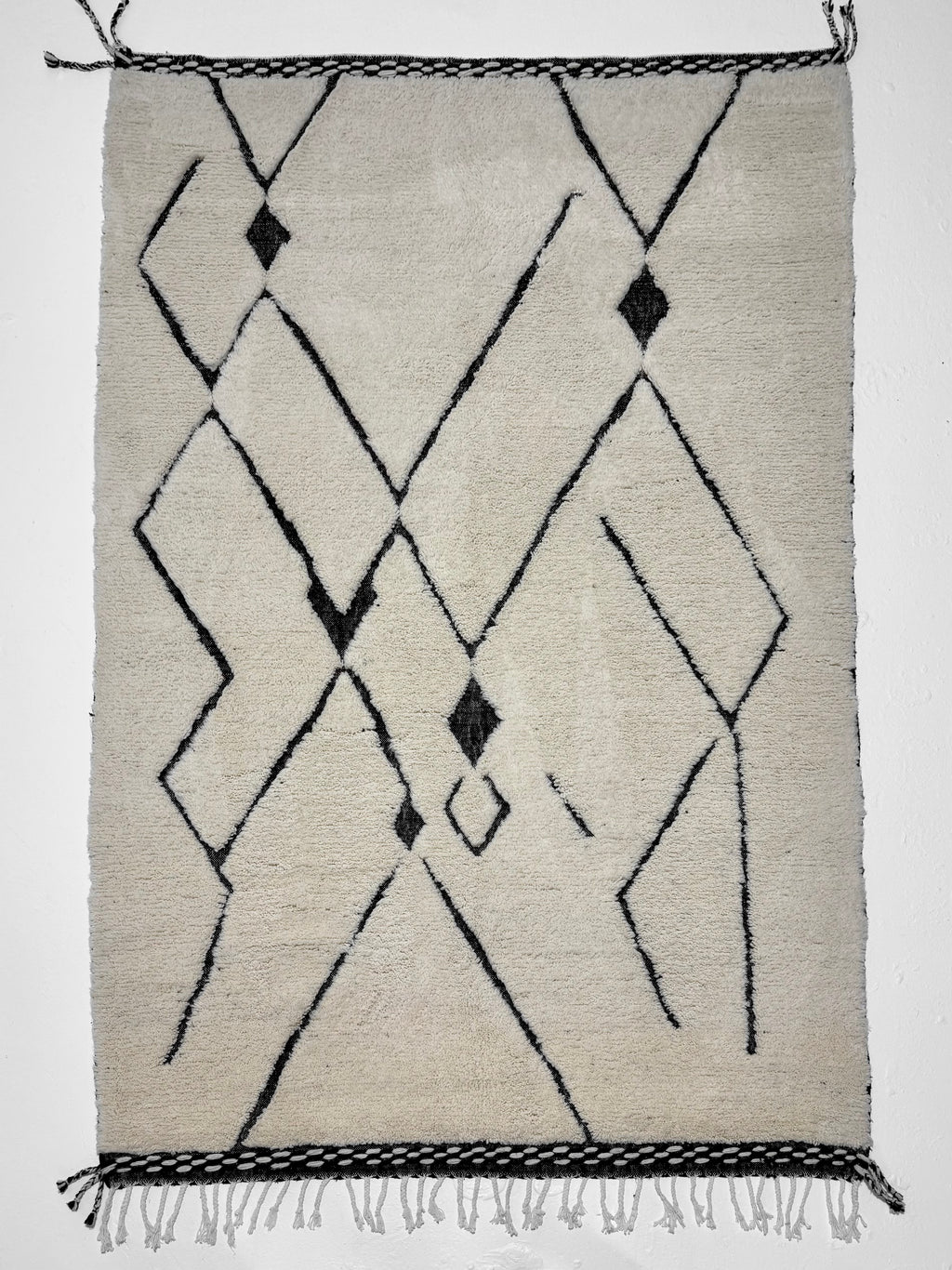 Geometric patterned rug with black lines on a light background
