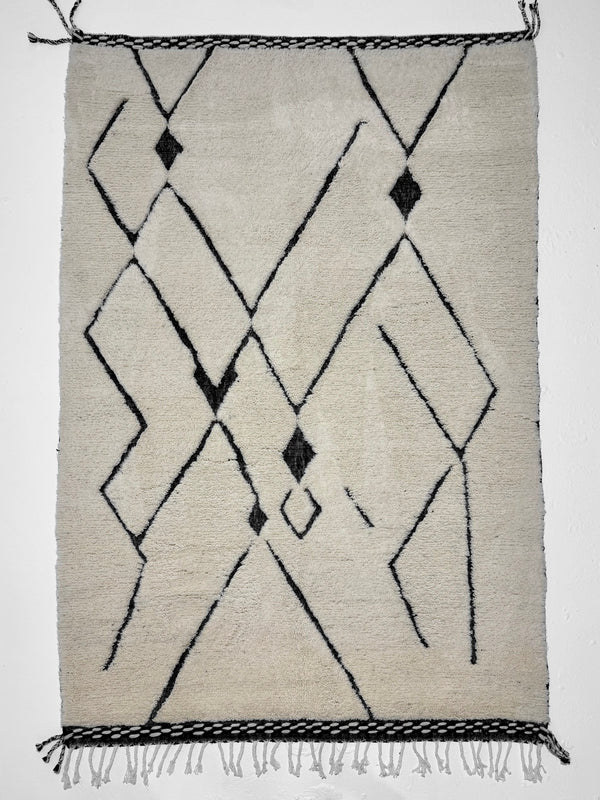 Geometric patterned rug with black lines on a light background