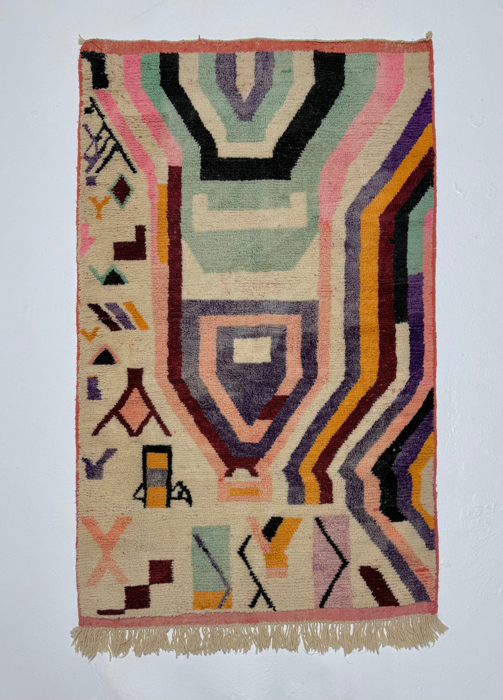 Geometric patterned rug with multicolor design on a plain background
