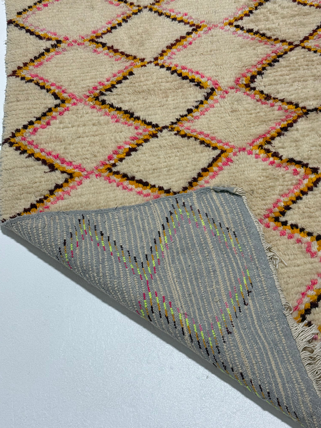 Close-up of two patterned rugs with geometric designs on a light background