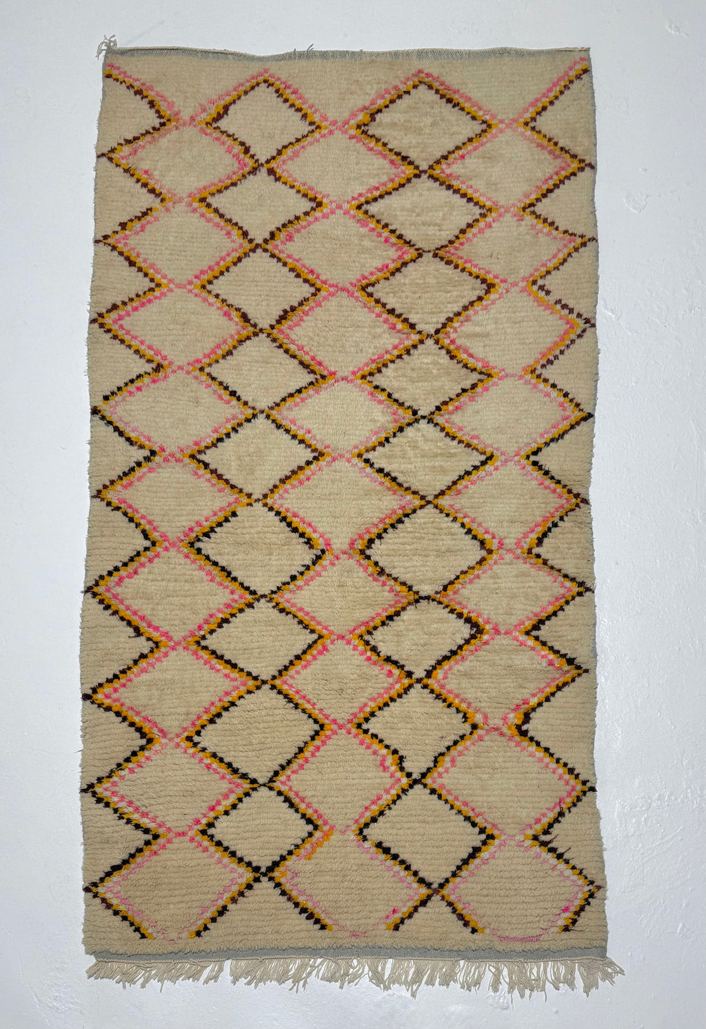 Woven rug with diamond pattern on a plain background
