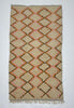 Woven rug with diamond pattern on a plain background