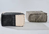 Two textured ottomans, one black and white, the other gray with a pattern, on a light gray background.