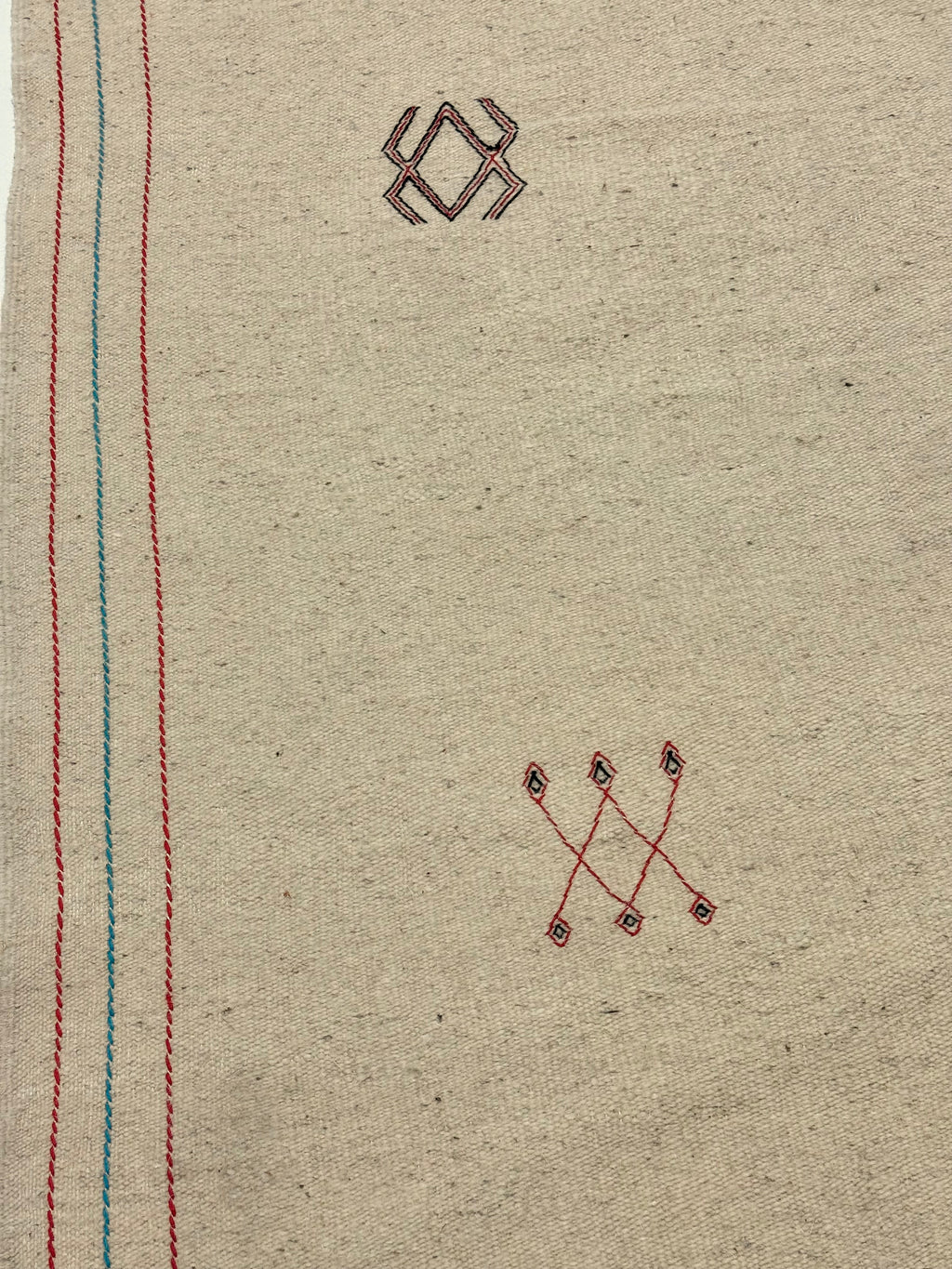 Textile with embroidered patterns on a beige background