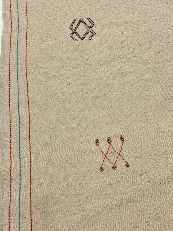 Textile with embroidered patterns on a beige background