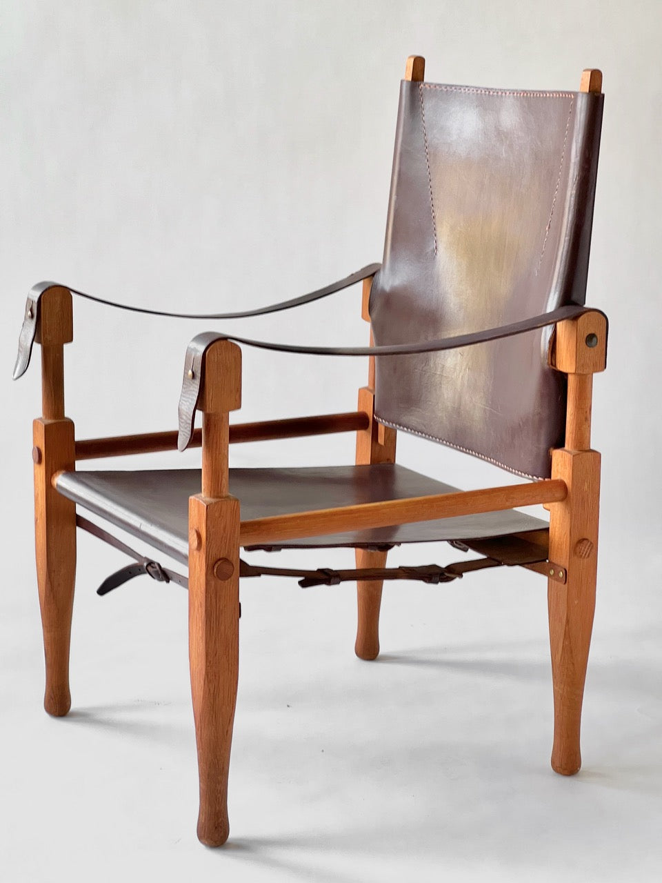 Wooden chair with brown leather seat and backrest on a white background