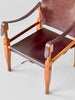 Brown leather chair with wooden frame on a light gray background