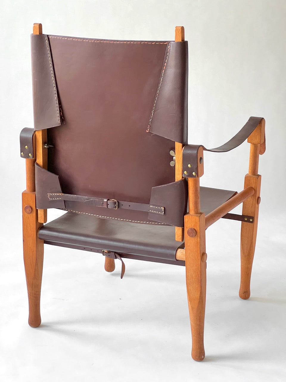 Brown leather chair with wooden frame on a white background