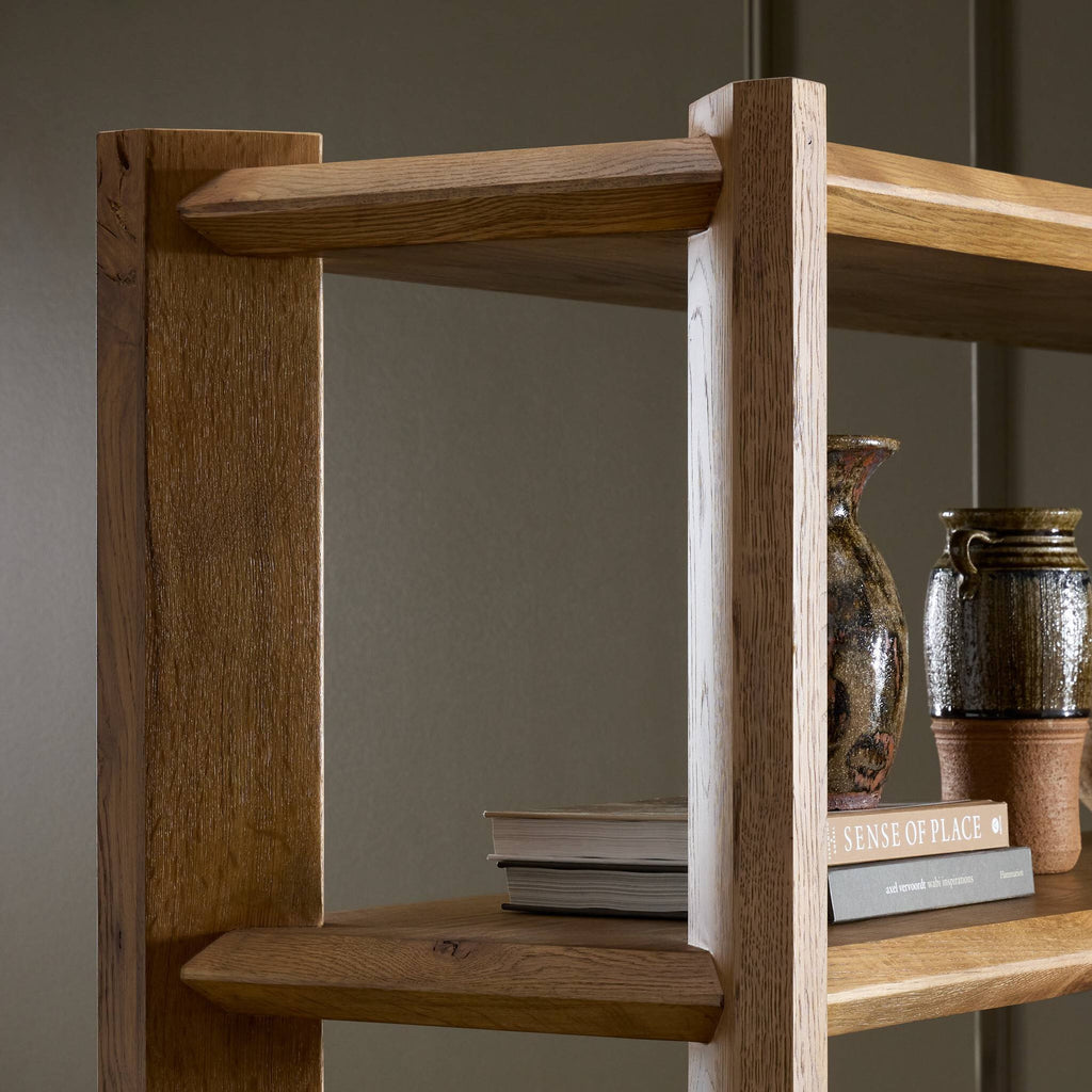 Wooden bookshelf with books and decorative items against a plain background