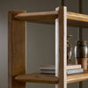 Wooden bookshelf with books and decorative items against a plain background