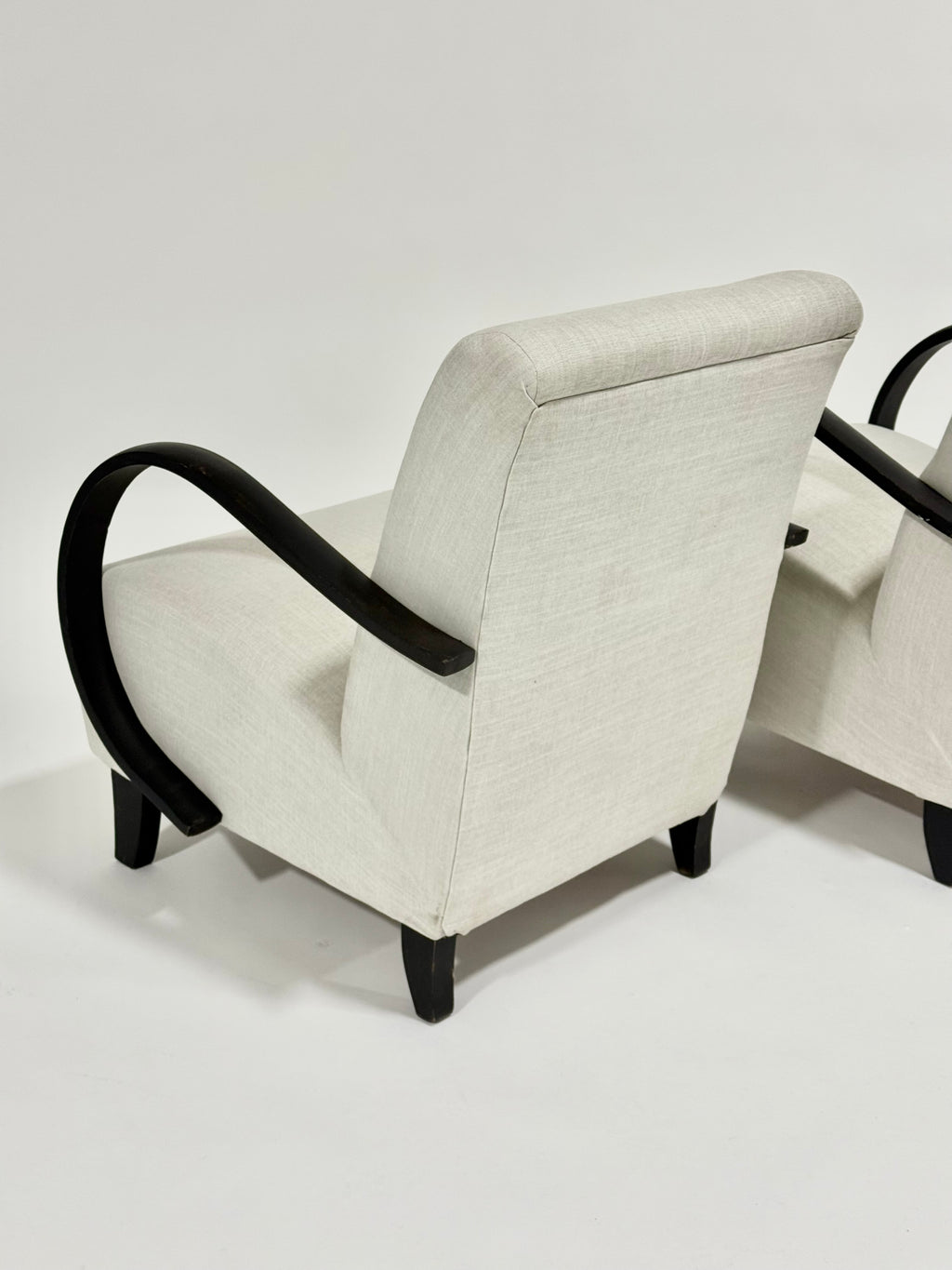 Beige armchair with black armrests on a white background