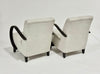 Two beige armchairs with black armrests on a white background