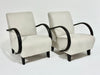 Two beige armchairs with black frames on a white background