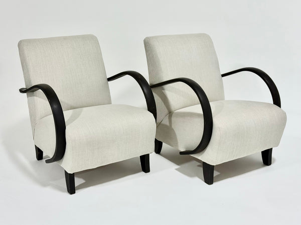 Two beige armchairs with black frames on a white background
