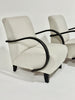 Two beige armchairs with black armrests on a white background