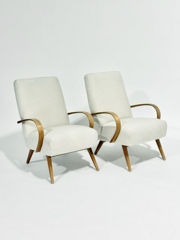 Two white armchairs with wooden frames on a light gray background