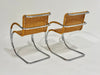 Two wicker chairs with metal frames on a light gray background