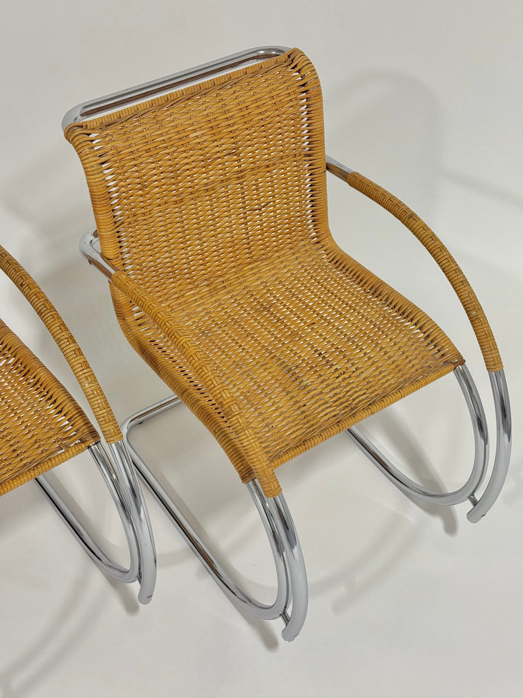 Wicker chair with metal frame on a plain background