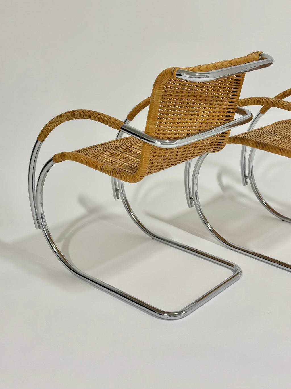 Woven chair with metal frame on a plain background