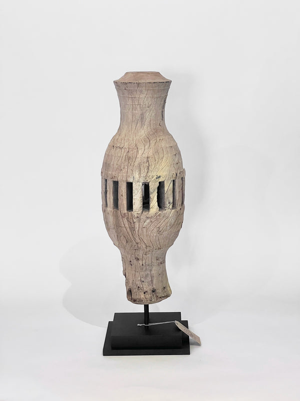 Wooden carved wheel vase with geometric design on a white background