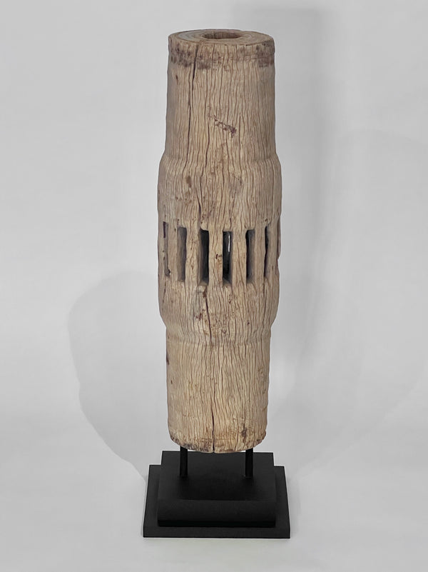 Wooden vase with a textured surface on a black stand against a white background