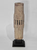 Wooden vase with a textured surface on a black stand against a white background