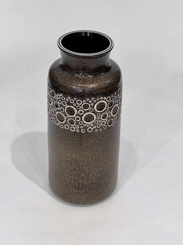 Brown ceramic vase with circular pattern on a white background