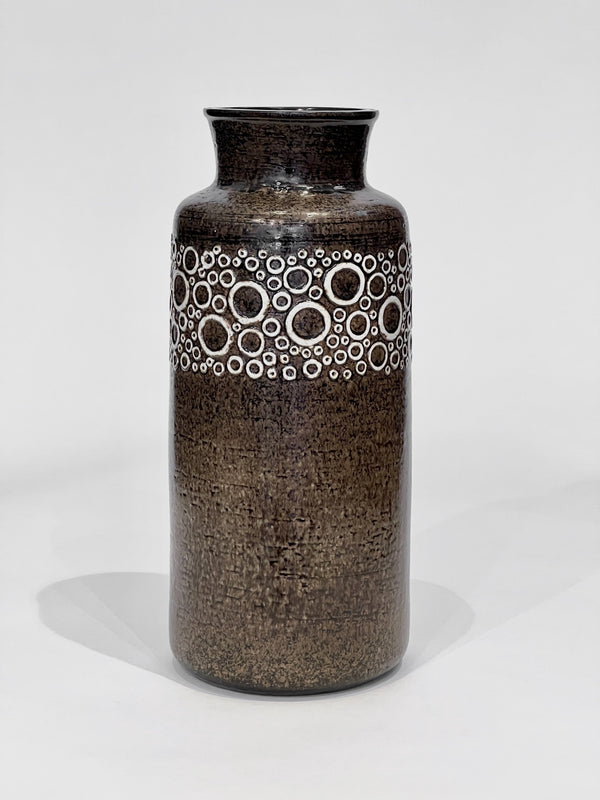 Brown ceramic vase with circular pattern on a white background