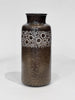Brown ceramic vase with circular pattern on a white background