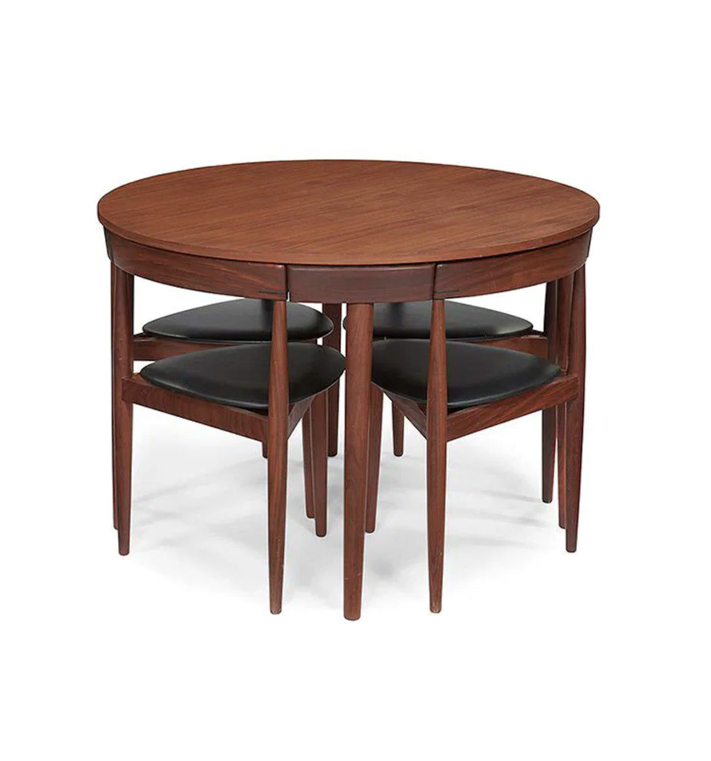 A round wooden dining table with four matching nesting chairs featuring dark cushioned seats, shown on a plain white background.