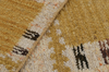 Close-up of a textured beige and brown rug with geometric patterns.